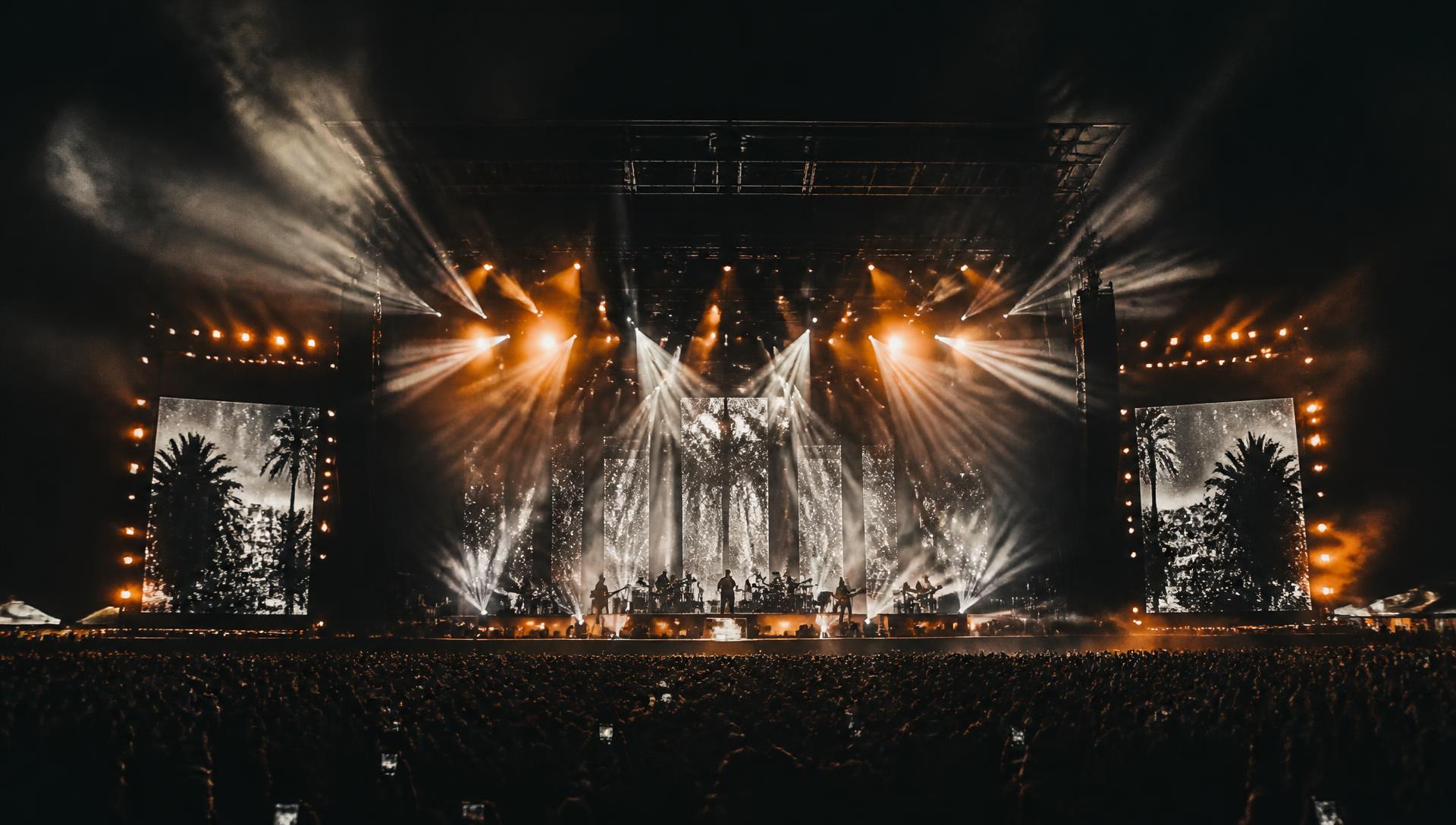 Concert stage lit by beams of light above a crowd